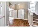 Inviting foyer with wood flooring, a staircase, and natural light streaming through a large arched window at 12812 Bradford Hill Ln, Huntersville, NC 28078