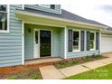 View of the front door, siding, and black shutters and trim at 12812 Bradford Hill Ln, Huntersville, NC 28078