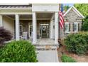 Inviting front porch with rocking chairs, stone accents, and decorative wreath at 132 Ragsdale Trl, Mooresville, NC 28117