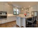 Modern kitchen featuring white cabinets, stainless steel appliances, granite countertops, and a large island at 1427 Main St, Charlotte, NC 28204
