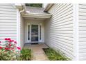 Close up of front entrance with glass storm door and colorful landscaping at 1445 Deer Forest Dr, Indian Land, SC 29707