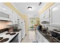 Bright kitchen features white cabinets, tile floors and a view into the breakfast nook at 1670 Robins Nest Ct # C, Gastonia, NC 28054