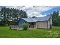 A quaint single story home with a metal roof and a wooden deck on a grassy lot at 1672 Riverview Rd, Lincolnton, NC 28092