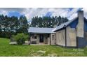 View of the house and deck, set on a grassy lot in a neighborhood at 1672 Riverview Rd, Lincolnton, NC 28092