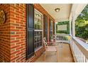 Inviting front porch with brick accents and comfortable seating, perfect for relaxing at 171 Highland Woods Ct, Denver, NC 28037