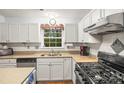 Well-lit kitchen with stainless steel appliances, including gas cooktop, and ample counter space at 171 Highland Woods Ct, Denver, NC 28037