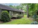 Backyard view featuring a cozy deck, mature trees, and a well-maintained lawn, ideal for outdoor living at 1748 4Th Street Ne Ct, Hickory, NC 28601