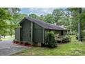 Side view of a charming home with a small wooden deck and lush surrounding greenery at 1748 4Th Street Ne Ct, Hickory, NC 28601