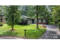 Charming home with lush front yard, a black asphalt driveway, and attached garage, perfect for suburban living at 1748 4Th Street Ne Ct, Hickory, NC 28601