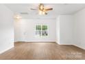 Open living space featuring wood floors, white walls, and a modern ceiling fan at 2005 Amos Oaks Ln, Charlotte, NC 28215