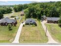 Aerial view of this home situated on a well-maintained, grassy lot surrounded by mature trees and other houses at 203 Poplins Grove Church Rd, Albemarle, NC 28001