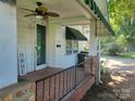 Inviting front porch features a ceiling fan, decorative 'HOME' sign, and patterned brick flooring at 3220 Harmony Hwy, Harmony, NC 28634