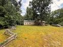 Cozy single-story home with a covered porch, surrounded by a lush green yard and mature trees at 370 Miracle Dr, Salisbury, NC 28146