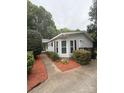 Inviting home exterior featuring manicured landscaping, a cozy entryway, and vibrant mulch beds enhancing curb appeal at 400 Archibald Rd, Concord, NC 28025