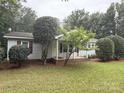 Charming single-story home with a well-maintained lawn and mature trees in a serene neighborhood at 400 Archibald Rd, Concord, NC 28025