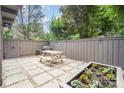 Outdoor patio with stone tiles, a grill, a picnic table, a fence and a raised garden bed with flowers at 4725 Rounding Run Rd, Charlotte, NC 28277