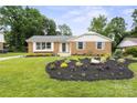 Charming brick home with a beautifully landscaped front yard and inviting curb appeal at 5817 Red Carriage Ln, Charlotte, NC 28212