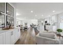 Spacious open-concept living area with hardwood floors connecting to a dining space and featuring built in cabinets at 5817 Red Carriage Ln, Charlotte, NC 28212