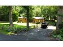 Exterior view of a house with a gravel driveway and mature trees at 5832 Thompson Rd, Charlotte, NC 28216