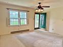 Bright living room featuring a ceiling fan, large window with natural light, and a green front door at 613 Catawba St, Chester, SC 29706