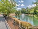 Scenic view of a pond with a fountain, surrounded by greenery and a walking path at 739 Elders Story Rd, Fort Mill, SC 29708