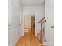Inviting entryway with hardwood floors and staircase, leading to a bright living area at 9701 Kent Village Dr, Charlotte, NC 28269