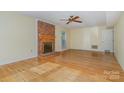 Spacious living room with hardwood floors, brick fireplace, and natural light at 9701 Kent Village Dr, Charlotte, NC 28269