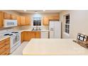 Well-lit kitchen with white appliances, a window over the sink, and plenty of counter space at 10105 Reindeer Way Ln, Charlotte, NC 28216