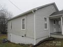Side view of a light gray home with white trim, windows, and a partial basement at 1110 20Th Ne St, Hickory, NC 28601
