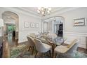 Elegant dining room with a glass table, modern chandelier and decorative rug at 11412 Preservation Ln, Charlotte, NC 28278