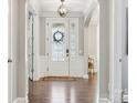 Bright foyer with a decorative front door, arched doorways, and wood flooring at 11412 Preservation Ln, Charlotte, NC 28278