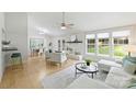 Bright living room with white brick fireplace, hardwood floors, and large windows at 11539 Five Cedars Rd, Charlotte, NC 28226