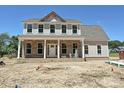 Charming two-story home with brick veneer, a covered porch, white columns, and complementary siding at 11543 Valley Oak Ln, Stanfield, NC 28163
