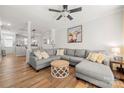 Spacious living room with hardwood floors, gray sofa, modern fan and neutral paint at 12342 Carrigan Ct, Huntersville, NC 28078