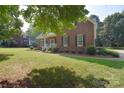 Well-maintained brick home with a welcoming front porch and mature landscaping at 14232 Kendalton Meadow Dr, Mint Hill, NC 28227