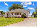 Lovely home boasts a cozy front porch and a driveway leading to a detached shed at 189 Lochshire Ln, Woodleaf, NC 27054