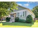 Beautiful craftsman-style home featuring a covered front porch, well-kept lawn, and complemented by mature trees at 232 Orange St, Charlotte, NC 28205