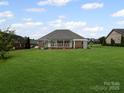 Expansive backyard featuring a screened-in porch and lush green lawn at 2872 Wheat Field Ct, Lincolnton, NC 28092