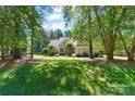 Beautiful home nestled among mature trees, with green lawn, and inviting walkway to the front door at 347 Bayberry Creek Cir, Mooresville, NC 28117