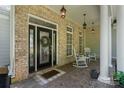 Inviting front porch with brick facade, decorative door, and charming rocking chairs at 347 Bayberry Creek Cir, Mooresville, NC 28117