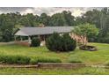 Brick home with carport and a partially landscaped yard featuring several green bushes and a stone-lined firepit at 356 Lucky Hollow Rd, Hickory, NC 28601