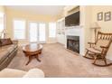 Cozy living room featuring a fireplace, built-in shelving, french doors and carpeted floor at 3697 Travertine Dr, Lancaster, SC 29720