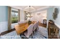 Dining room with table set for six, large windows, and decorative wall hangings at 7030 Butternut Oak Ter, Huntersville, NC 28078