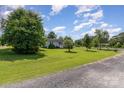 Spacious front yard with large mature trees surrounding a charming light blue home at 7785 Crestwood Dr, Kannapolis, NC 28081