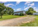 Exterior view of a single-story home with a large grassy yard and mature trees at 7785 Crestwood Dr, Kannapolis, NC 28081