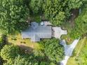An aerial view of the house with a deck, driveway, and is surrounded by lush greenery and mature trees at 8101 Truelight Church Rd, Mint Hill, NC 28227