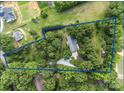 An aerial view of the property outlined in blue, surrounded by lush greenery and mature trees at 8101 Truelight Church Rd, Mint Hill, NC 28227
