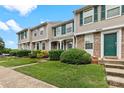 Well-kept townhomes with vibrant green doors and shutters, framed by lush landscaping at 9606 Vinca Cir # E, Charlotte, NC 28213