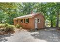 Well-maintained brick home with a metal roof, lush landscaping, and private access to the lake at 9763 Pine Tree Ln, Norwood, NC 28128