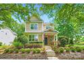 Charming two-story home featuring a covered porch, stone accents, and landscaped front yard at 10132 Caldwell Depot Rd, Cornelius, NC 28031